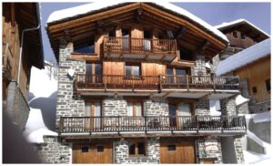 Chalet alpin en bois et pierre à La Rosière recouvert de neige